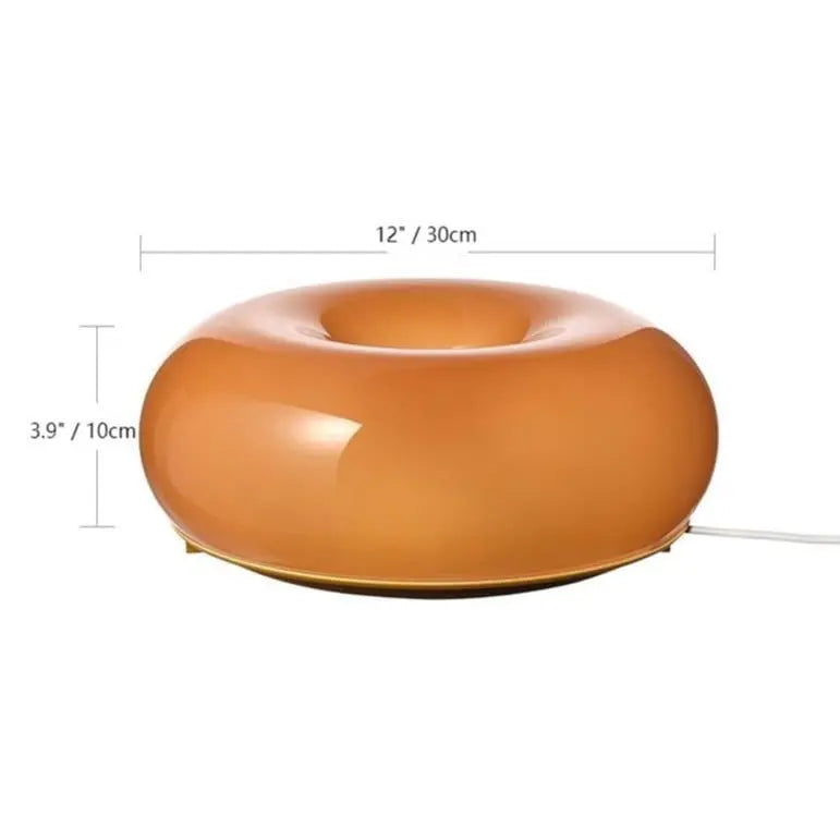 Witte LED donut lamp van glas, multifunctioneel als tafel- of wandlamp. Stijlvol interieur.