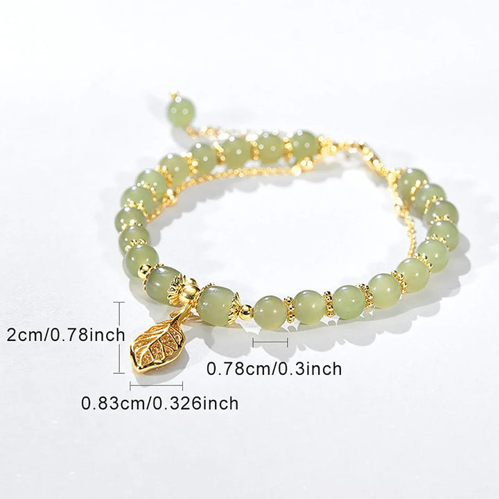 Prachtige dames jade armband met unieke vergulde bladbedel. Dit elegante edelsteen sieraad brengt balans.