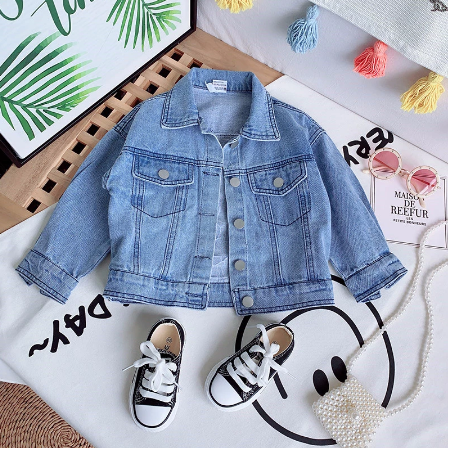 Detaillering van trendy kinderspijkerjasje, zachte denimstof. Casual jongens- of meisjesjas voor frisse zomeravonden.