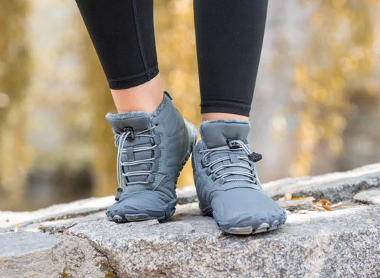 Persoon draagt antislip unisex barefoot schoenen tijdens een winterwandeling, voor veiligheid en comfort.