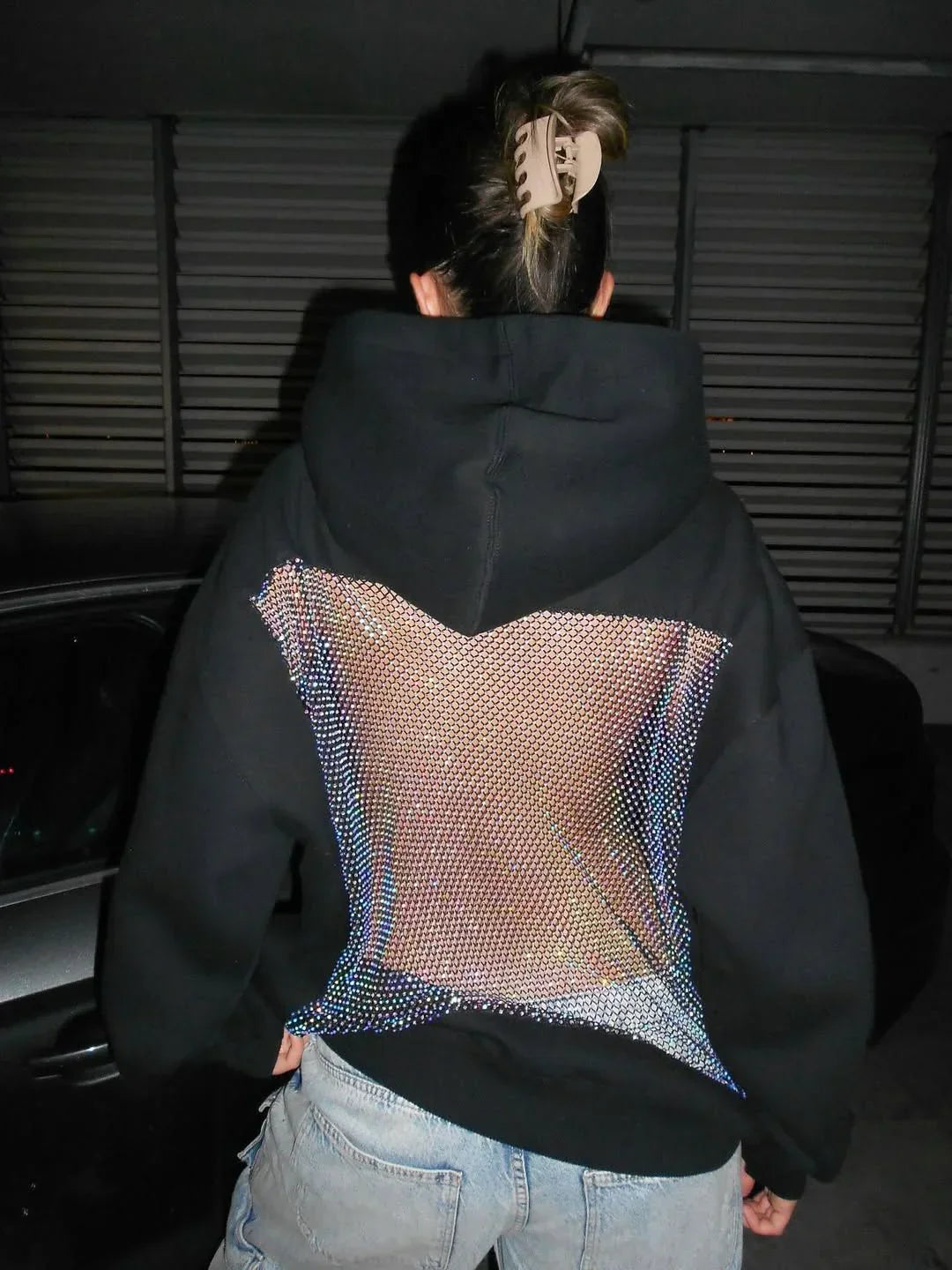 Stijlvolle dames glittertop met open rug design; een comfortabele hoodie voor een unieke mode statement.
