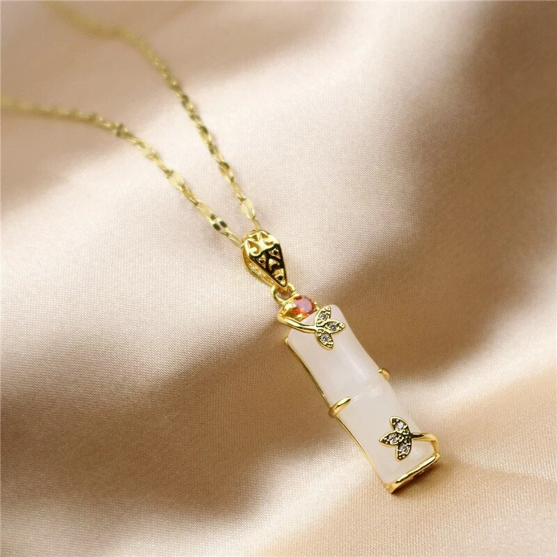 Close-up van de groene jade amulet aan een delicate damesketting. Tijdloos sieraad voor geluk en rijkdom.