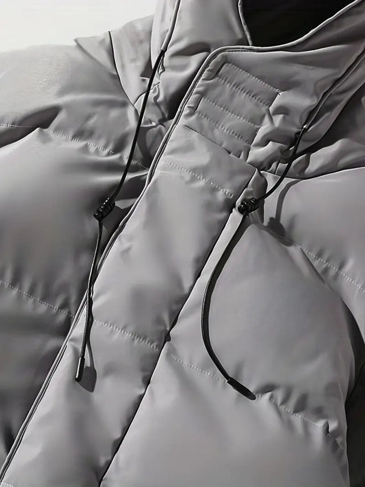 Warme heren winterjas, lange puffer model met capuchon in elegant grijs; comfortabele buitenkleding.