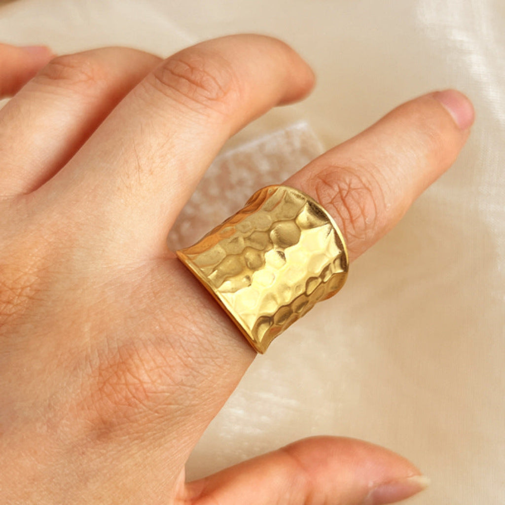 Unisex brede open gouden ring van edelstaal met gehamerd watergolfpatroon. Verstelbaar statement sieraad voor elke mode.