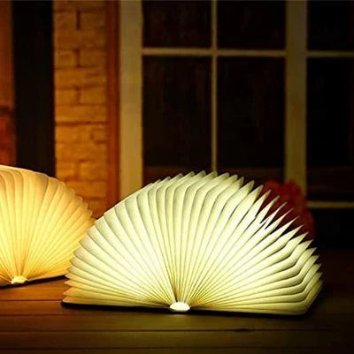 Vrouw leest comfortabel bij het warme licht van de opvouwbare StoryGlow LED boekenlamp.