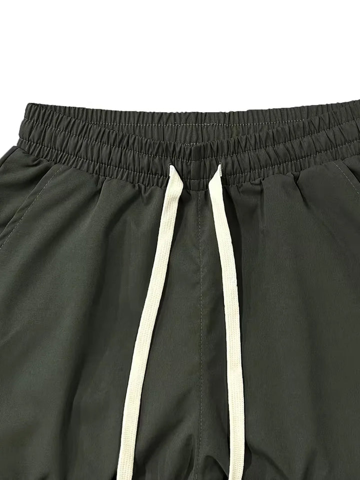 Man draagt moderne heren taps toelopende cargo broek met elastische boorden, ideaal voor een actieve lifestyle.