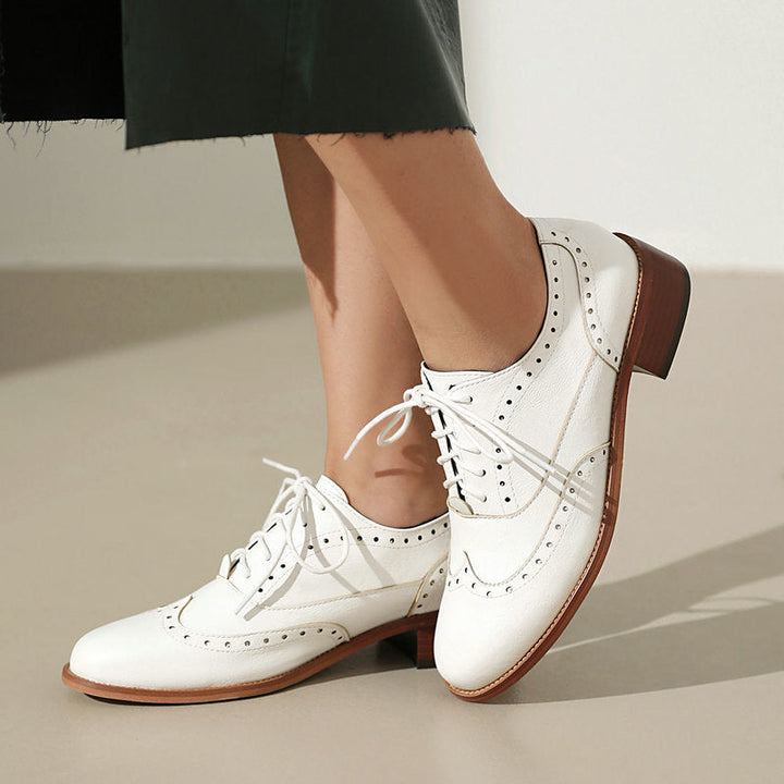 Elegante veterschoenen met subtiele perforaties, ontworpen voor dames die houden van formele en comfortabele schoenen.
