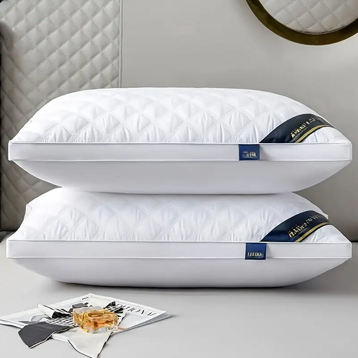 Set van 2 hypoallergene kussens op een bed, klaar voor een luxe slaapervaring met nekondersteuning.