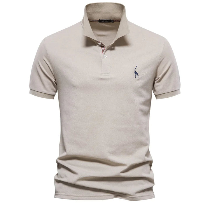 Man draagt een comfortabele herenpolo met hertenborduursel; ideale casual zomerkleding voor elke man.