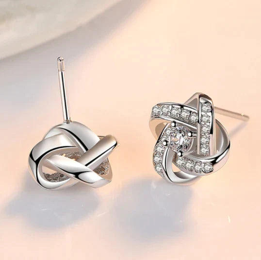 Verzilverde Liefdesknoop oorbellen voor dames, met zirkonia stenen. Matcht perfect met de ketting.