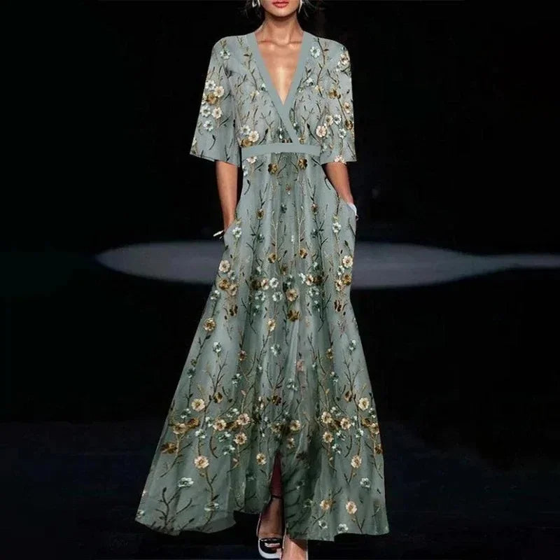 Dames maxi jurk met opvallende print, V-hals en praktische zijzakken, combineert stijl met functionaliteit.