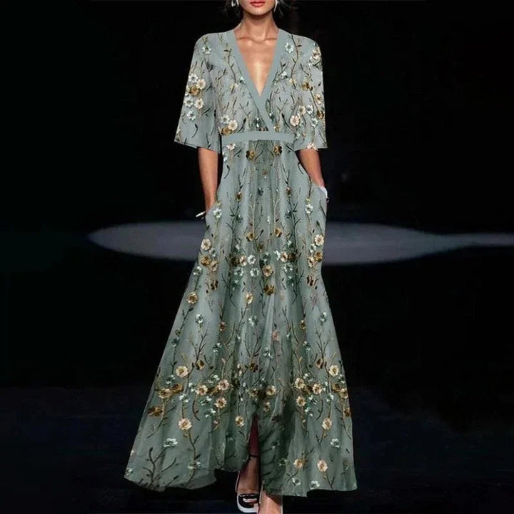 Dames maxi jurk met opvallende print, V-hals en praktische zijzakken, combineert stijl met functionaliteit.