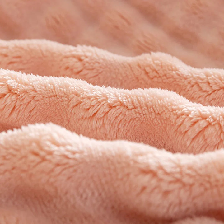 Iemand ontspant onder de heerlijk warme en zachte PlushBubble flanellen comfortdeken voor ultiem gemak.