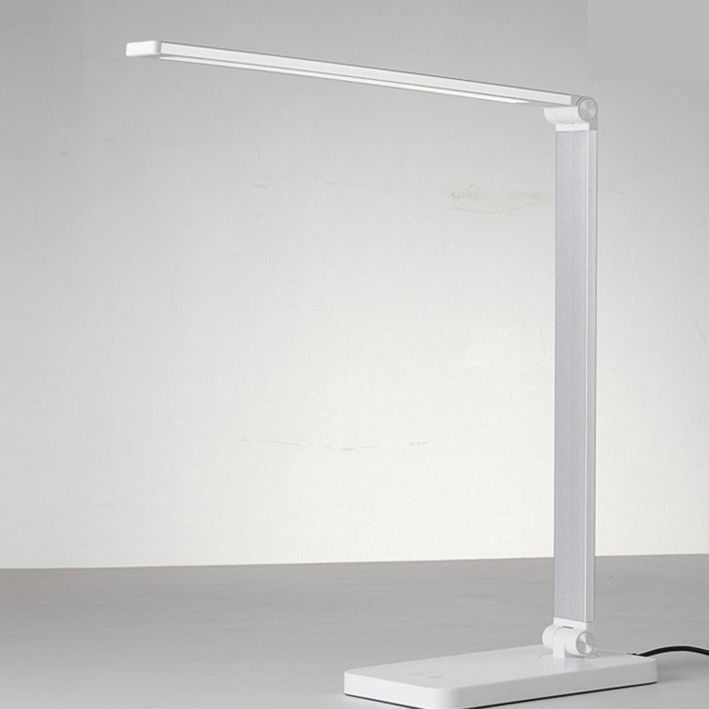 Stijlvolle LumiGlow dimbare LED-bureaulamp op bureau, inclusief draadloze oplader voor smartphone.