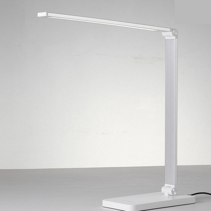 Stijlvolle LumiGlow dimbare LED-bureaulamp op bureau, inclusief draadloze oplader voor smartphone.