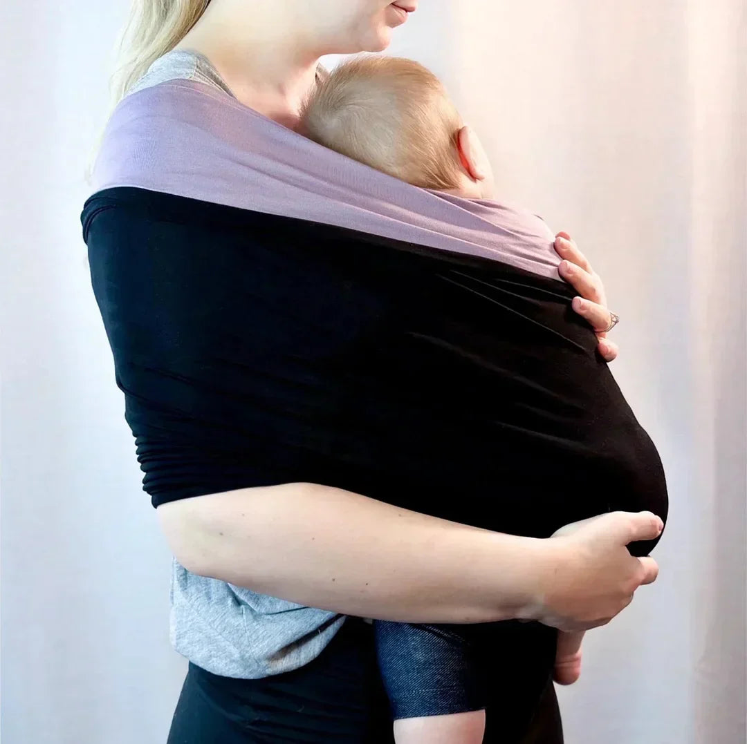 Actieve ouder met baby handsfree in ondersteunende draagdoek. Comfortabel, veilig en ergonomisch voor peuter & baby.
