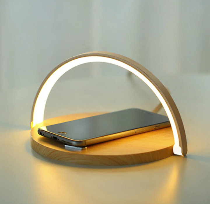 Draadloze oplader met geïntegreerde LED nachtlamp en telefoonhouder; ideaal voor je smartphone op nachtkastje.