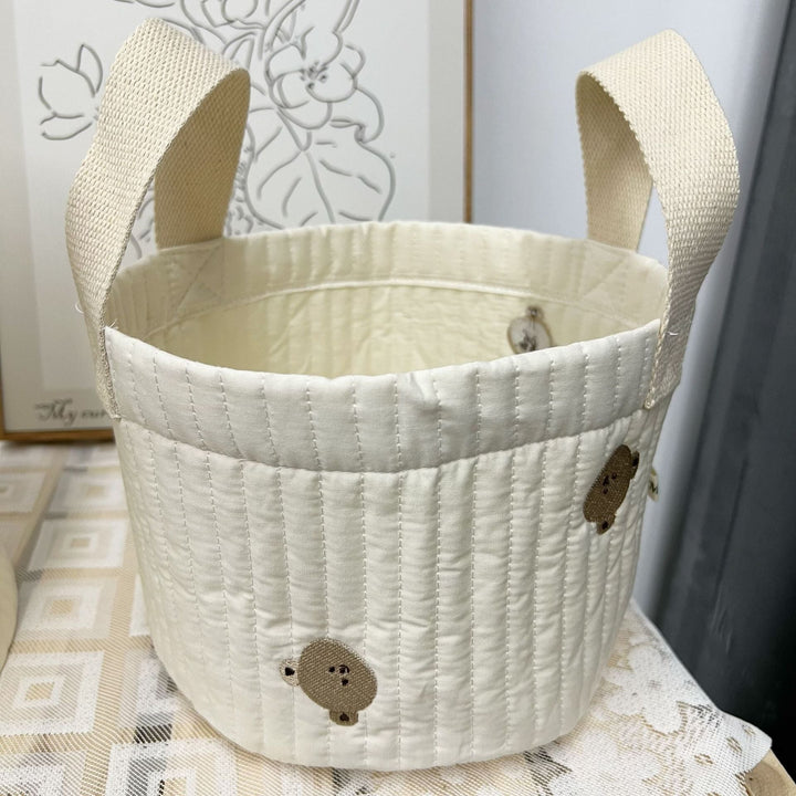 Lege gewatteerde stoffen opbergtas, klaar om speelgoed of kleding te organiseren in babykamer.