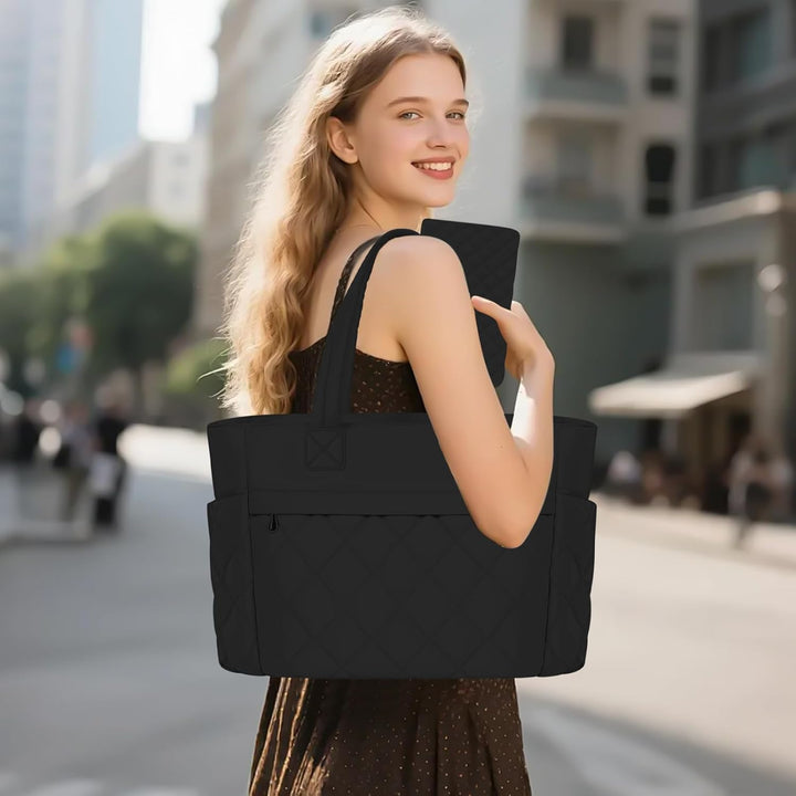 Dame draagt elegante zwarte Selvara laptoptas (15.6 inch) over de schouder, ideaal voor kantoor en onderweg.