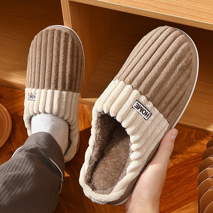 Herenvoeten genieten van de warmte en het comfort van deze instapper pantoffels thuis.