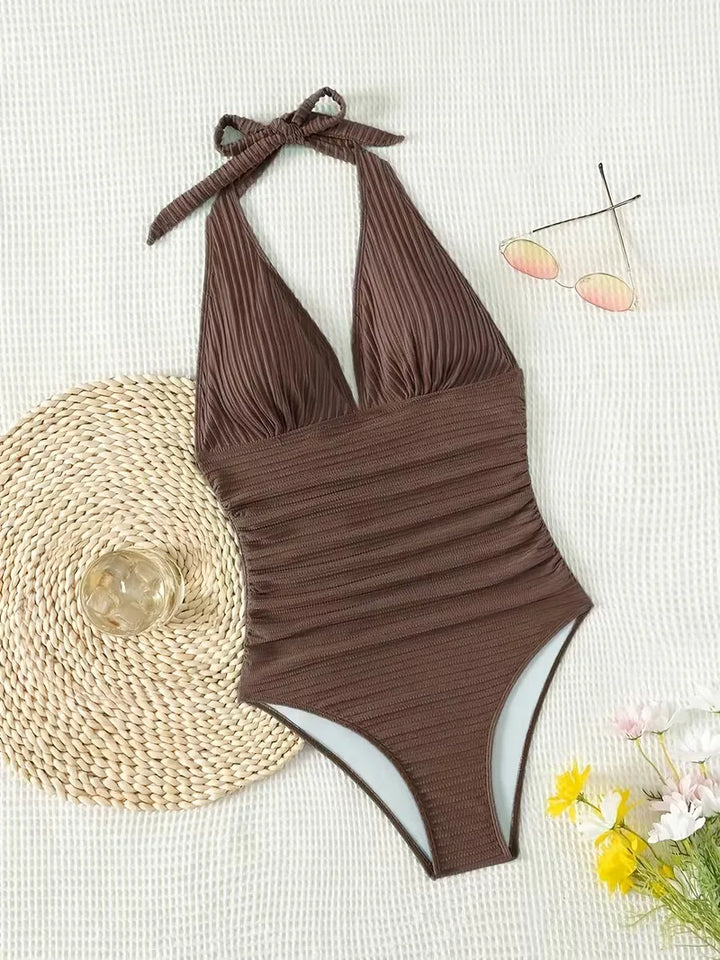 Flatterend donkerbruin dames badpak met V-hals en halternek, corrigerende zwemkleding voor de zomer.