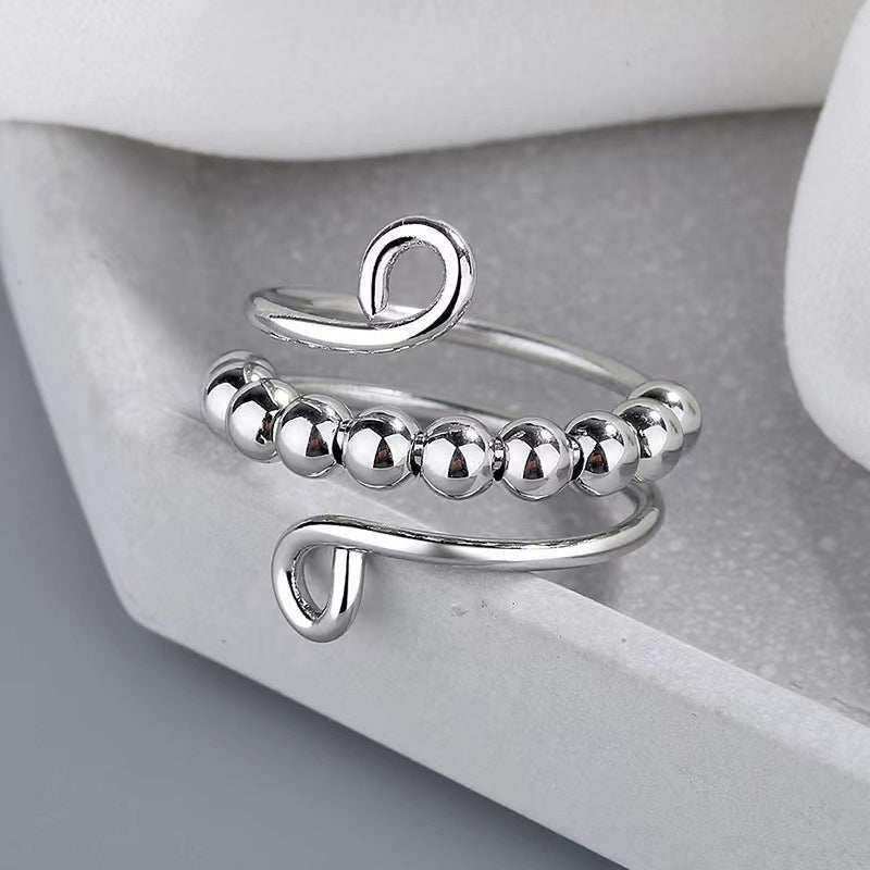 Zilverkleurige fidget ring met draaibare kralen, ideaal voor angstvermindering.