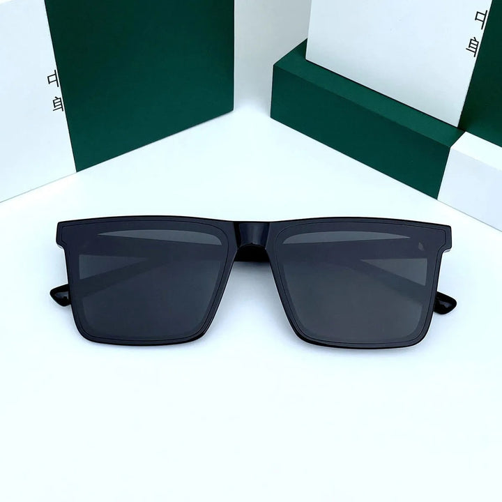 Heren vintage zonnebril met glanzend zwart rechthoekig montuur en donkere UV-filter glazen. Luxe en modern.