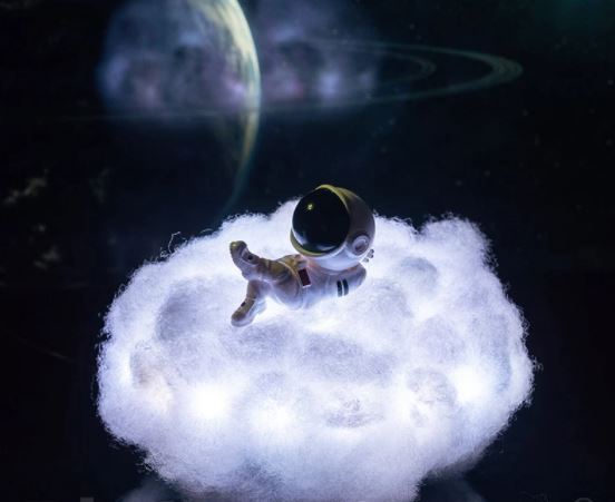 Astronaut staand op een kleurrijke LED wolk, rustgevend nachtlampje en sfeerlamp voor de slaapkamer.
