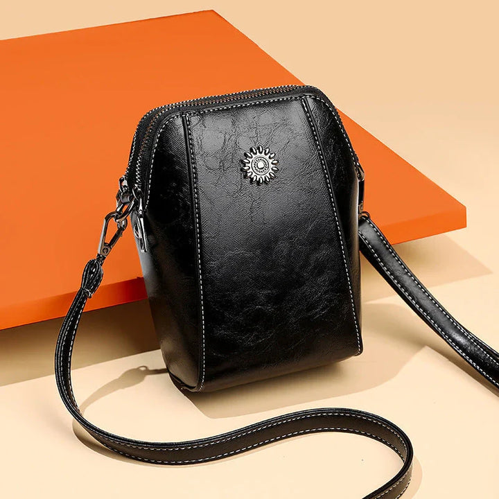 Zwarte Charina crossbody schoudertas voor dames, een elegant kunstleer accessoire met praktische ritssluiting en mode-uitstraling.
