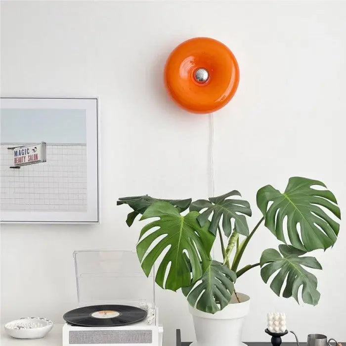 Witte donut LED wandlamp van glas, minimalistisch en functioneel voor hedendaagse interieurs.