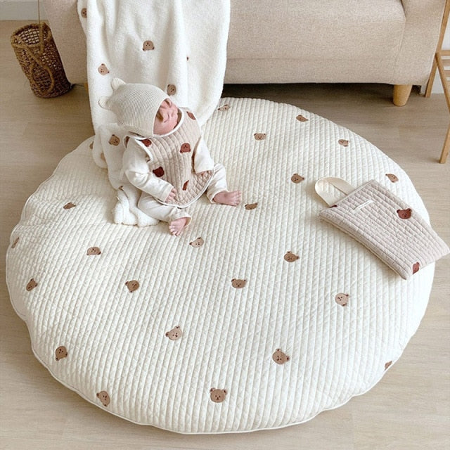 Zachte textuur van de gewatteerde katoenen kruipmat met geborduurde dieren, perfect voor baby's en peuters.