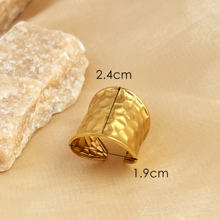 Verstelbare brede open ring unisex, goudkleurig edelstaal. Gehamerd watergolfpatroon maakt dit een uniek modesieraad.