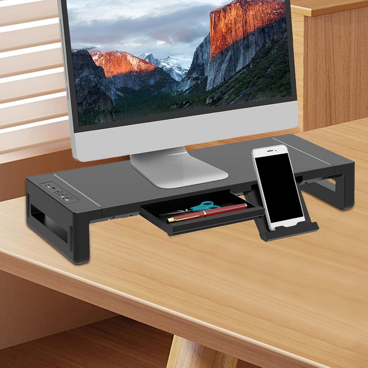 Nette werkplek met zwarte verstelbare monitorstandaard, inclusief lade en USB poorten.