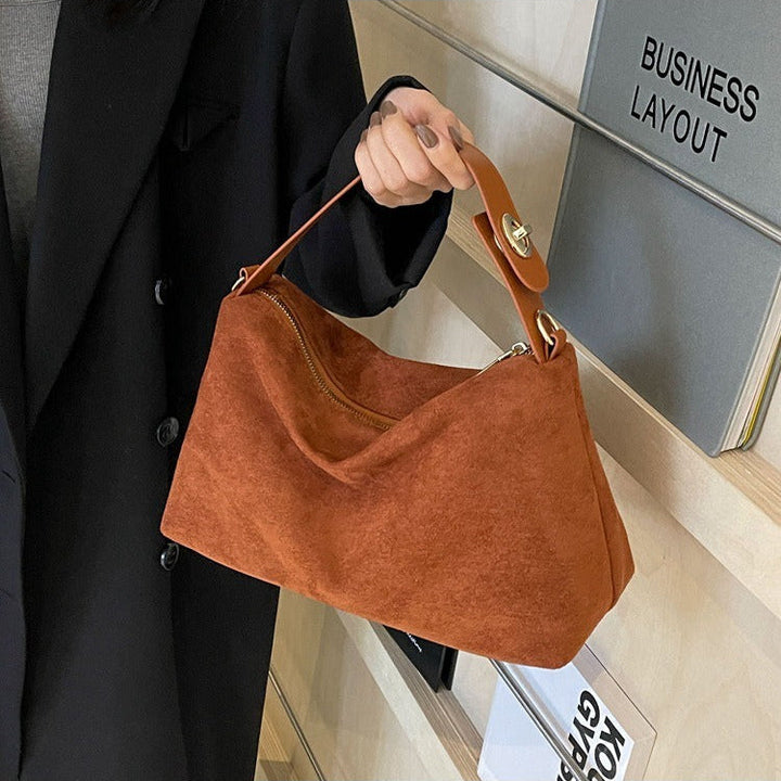 Bruine retro suède schoudertas voor dames; een stijlvol mode-accessoire met tijdloze elegantie.