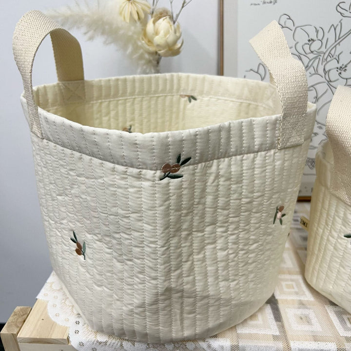 Decoratieve gewatteerde stoffen opbergtas, draagt bij aan stijlvolle kinderkamer inrichting.