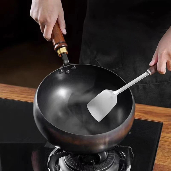 Traditionele gietijzeren wadjan van Cuyun, PFAS-vrij en krasbestendig, voor authentieke gerechten.