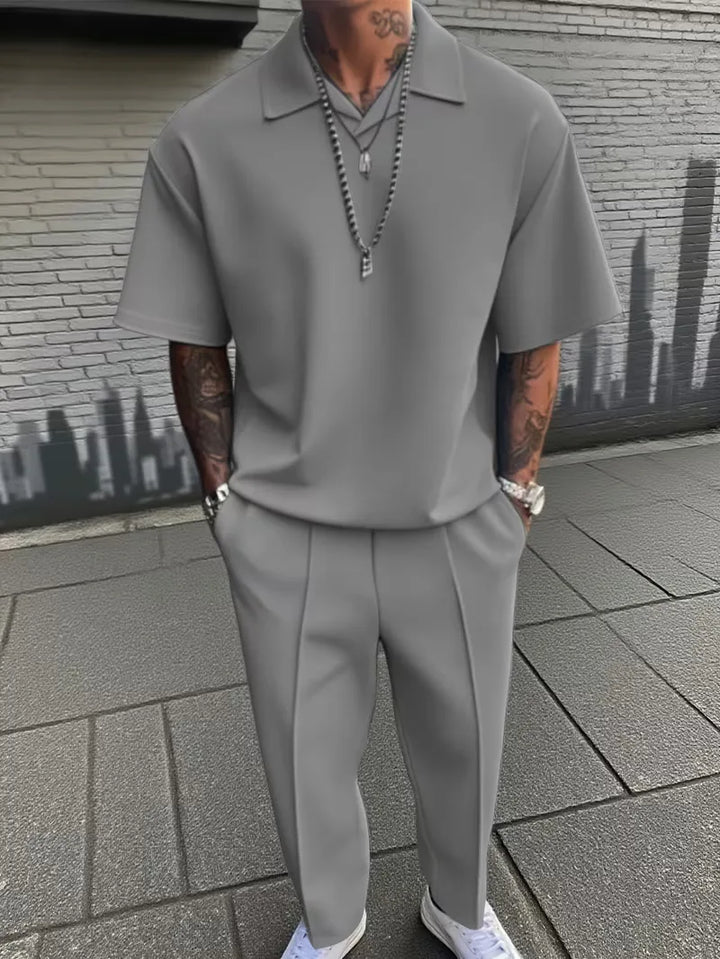 Fris herenpak, korte mouwen polo en rechte broek, smart-casual stijl voor de warmere dagen.