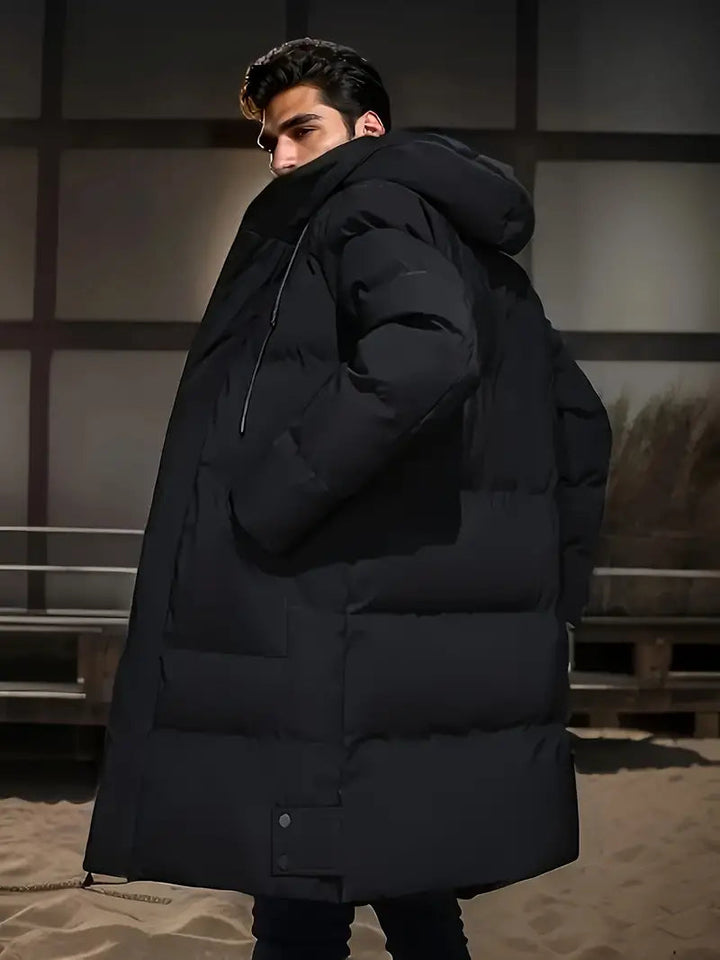 Heren lange zwarte puffer winterjas met capuchon; warm, stijlvol en comfortabel voor koude dagen.