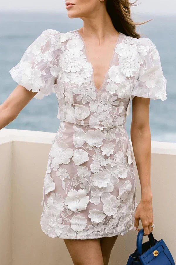 Veelkleurige bloemen mini jurk met elegante pofmouwen. Een zwierige lente/zomer damesjurk.