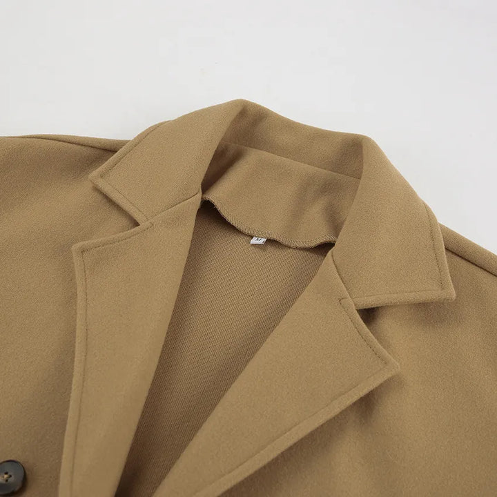 Halflange bruine damesjas met dubbele knoopsluiting, een must-have voor een klassieke garderobe.