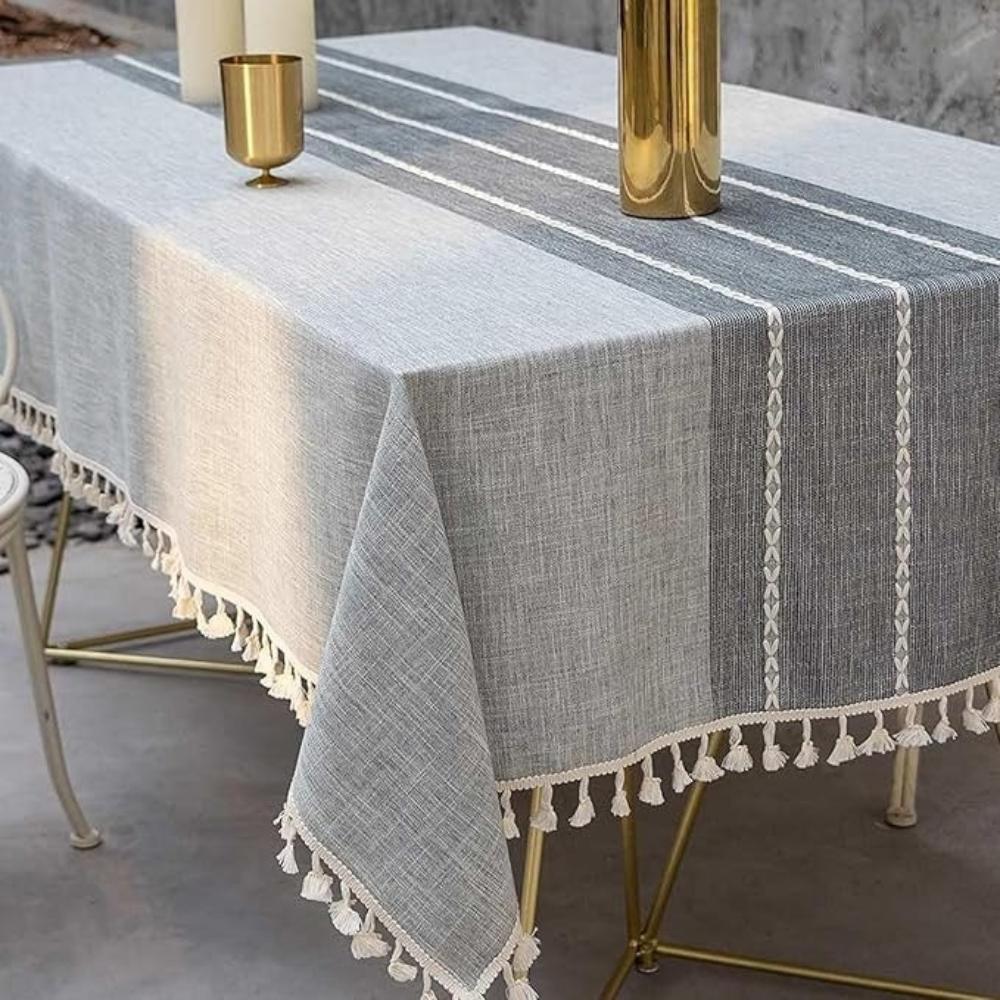 Grijs linnenlook tafelkleed met geometrisch dessin en kwastjes, perfect voor landelijk interieur.