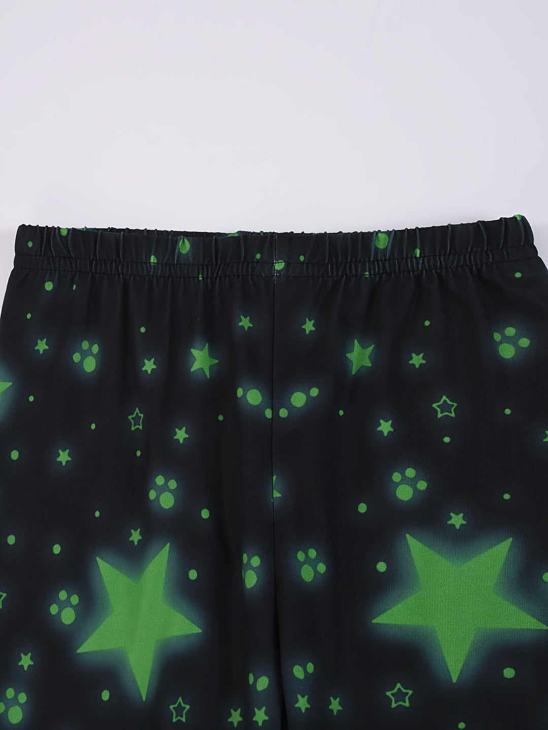 Detail van glow-in-the-dark dinosaurus print op zachte kinderpyjama. Nachtkleding voor avontuurlijke dromers.