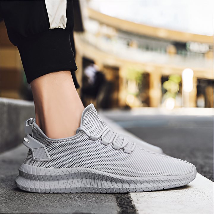 Man draagt zwarte lichtgewicht orthopedische herenschoenen, casual en comfortabel voor een actieve dag.