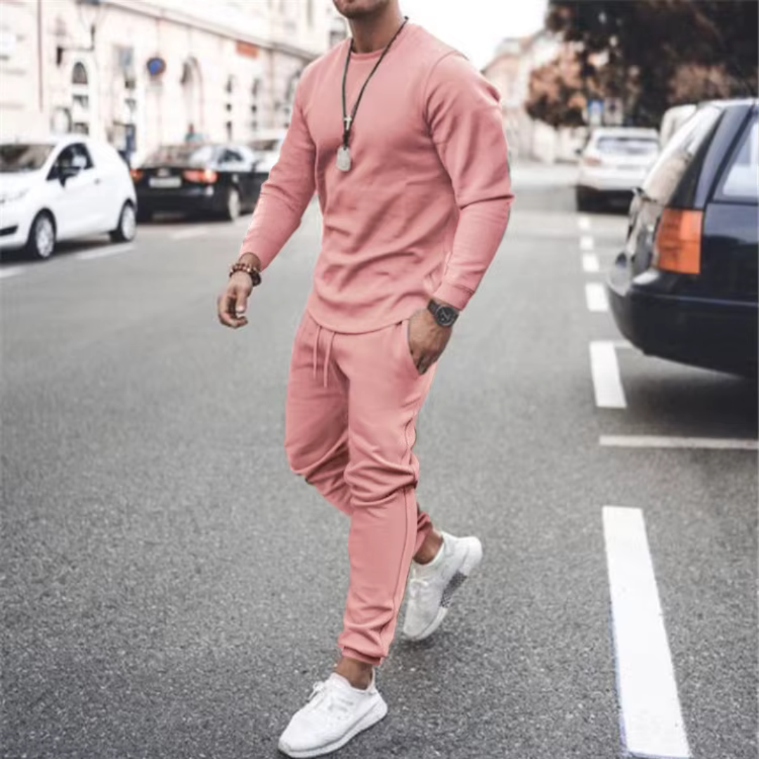 Model draagt een comfortabele Hoymans heren set, tweedelig trainingspak, perfect voor vrije tijd en sport.