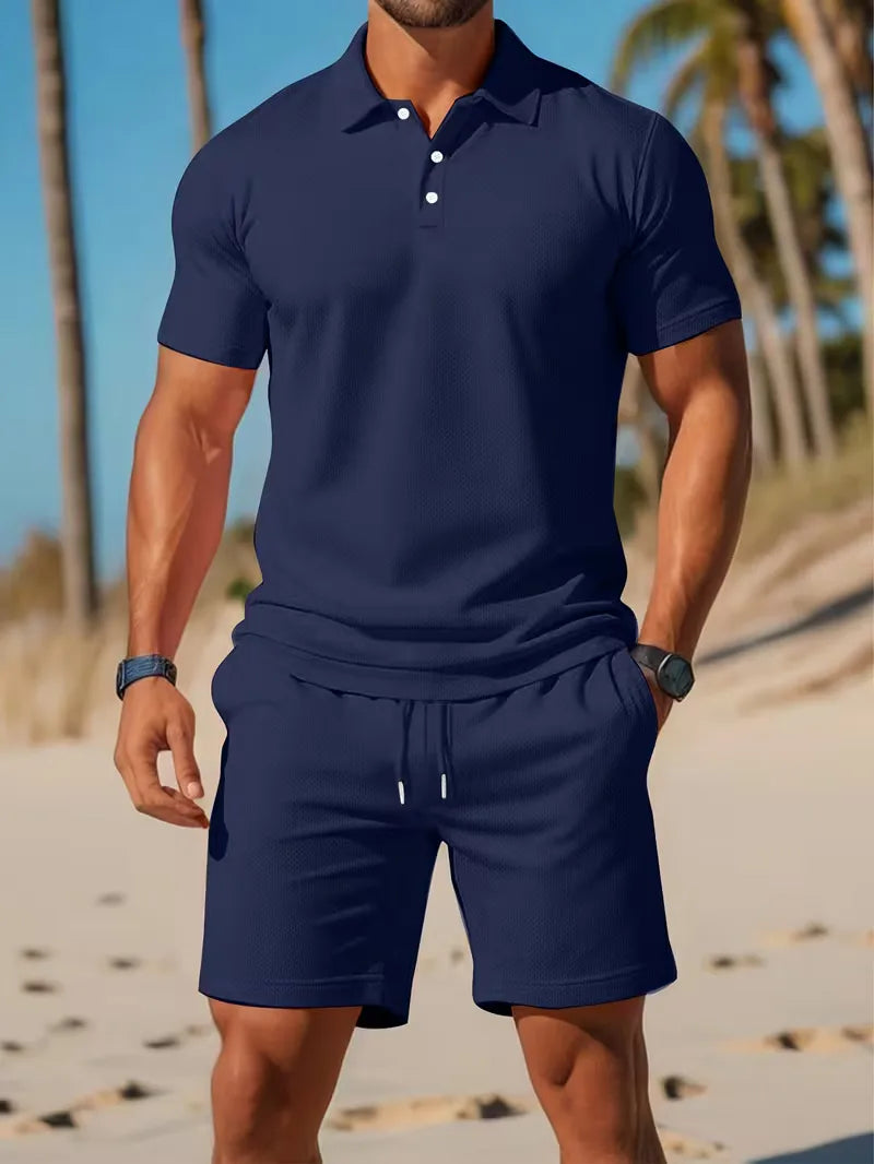 Zomerse heren outfit: lichtblauwe V-hals polo en witte shorts, comfortabele tweedelige set.