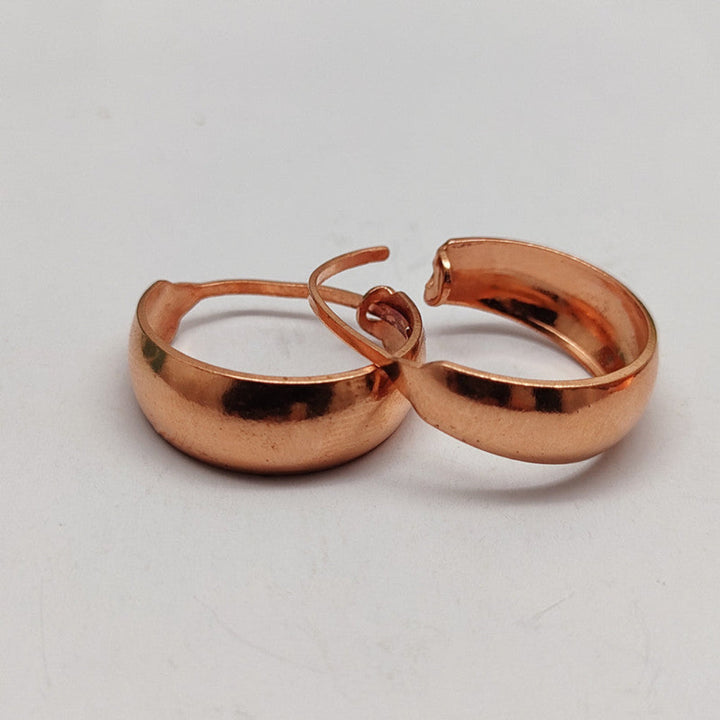 Trendy U-vormige dames oorbellen van roségoud en koper, met unieke getextureerde afwerking.