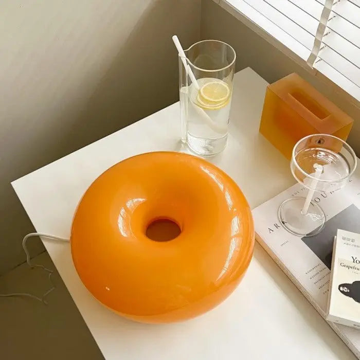 Oranje glazen donut LED lamp, zowel tafellamp als wandlamp, veelzijdig en stijlvol.