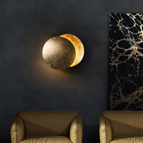 Gouden ronde LED wandlamp Lunora, creëert warme maangloed. Perfect voor woonkamer of slaapkamer.