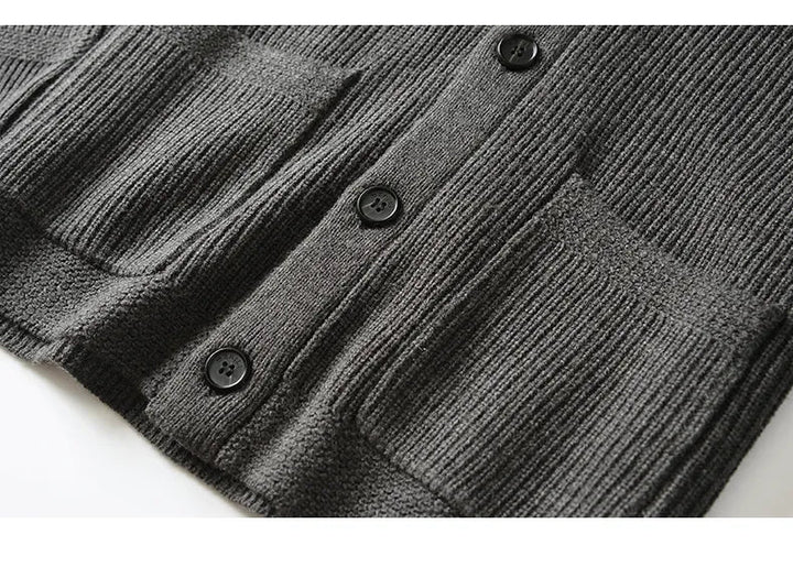 Model draagt een warm, grijs merinowol heren vest met knopen, perfect voor winter.