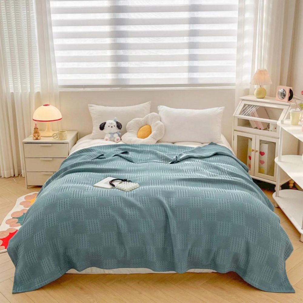 Comfortabele biologisch katoenen wafeldeken in neutrale kleur op bed, zacht en stijlvol huistextiel.